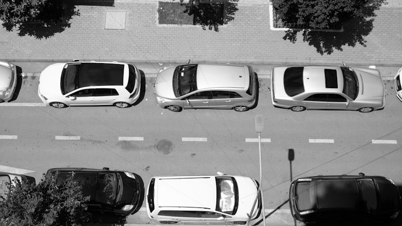 A black and white photo of cars parked on a street