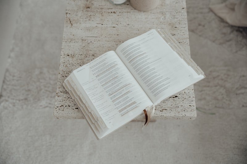 An open book with white pages on a textured surface