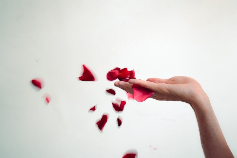 A woman's hand holding a piece of red tissue paper