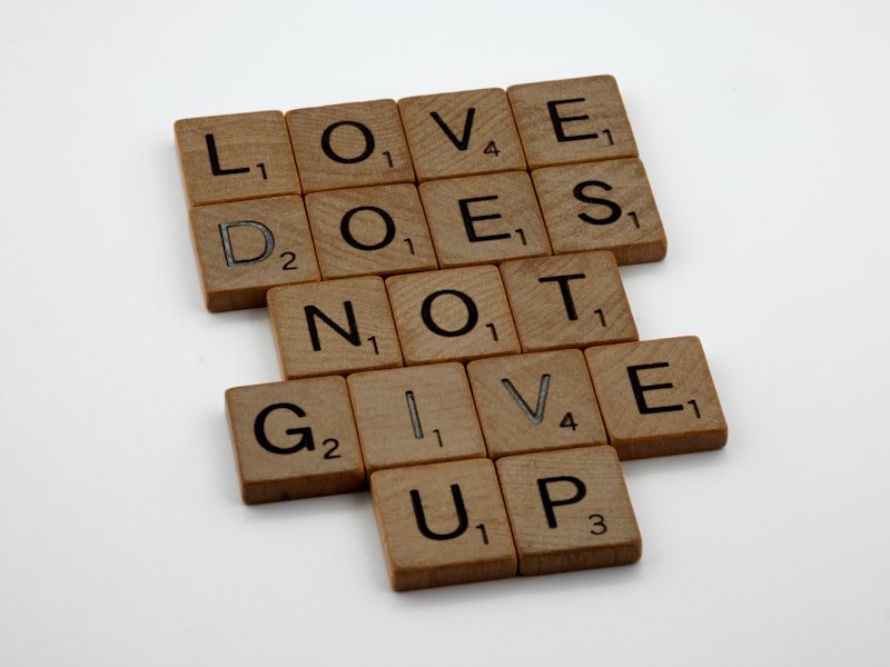 a scrabble tile with the words love does not give up