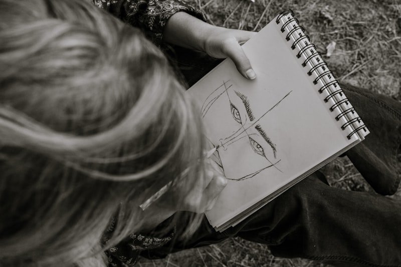 girl in black shirt holding white notebook