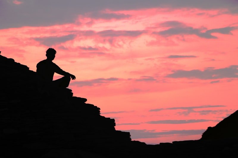 silhouette of person across orange sky