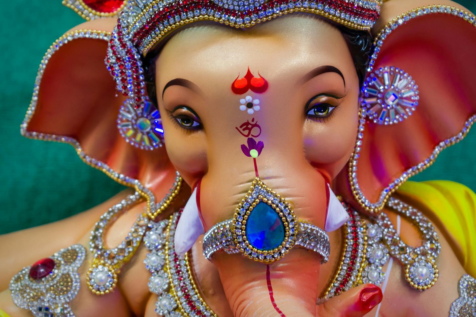 Close-up of a richly adorned Ganesha statue showcasing exquisite details and vibrant colors.