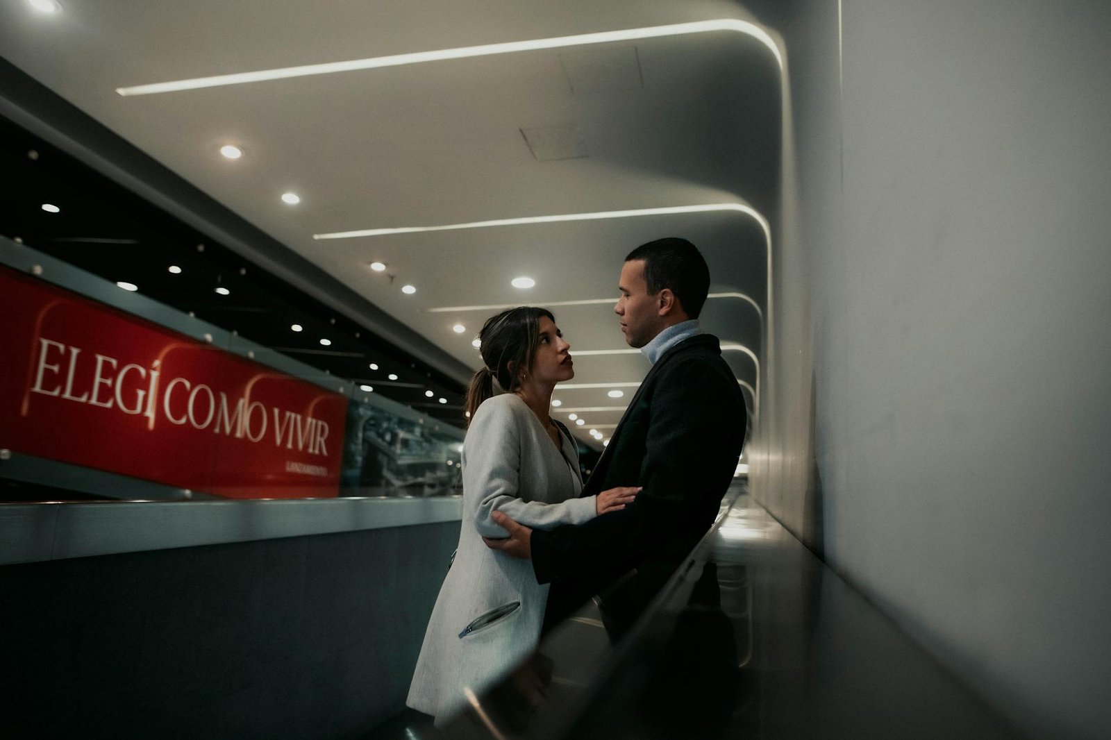 A couple shares a tender moment inside a modern building in Buenos Aires.