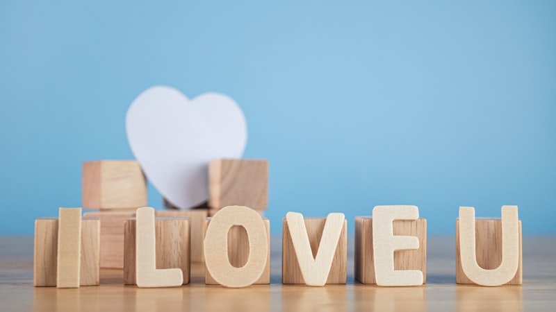 a wooden block spelling i love u with a white heart