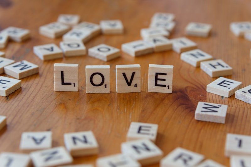 A wooden table topped with scrabble letters spelling love