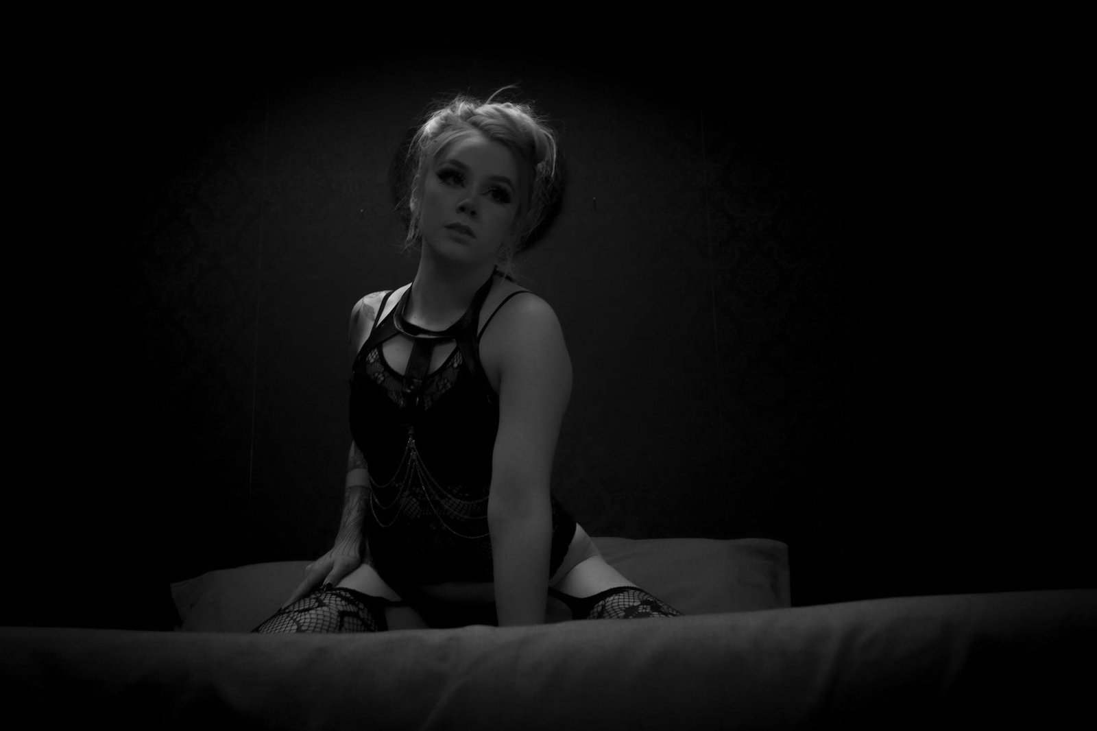 Elegant portrait of a woman in a dramatic black and white setting, evoking a moody ambiance.