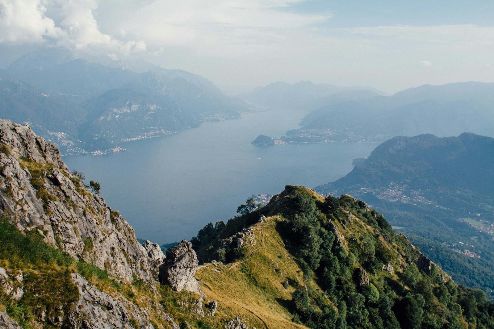 Experience the breathtaking view of Lake Como surrounded by lush mountains and scenic cliffs.