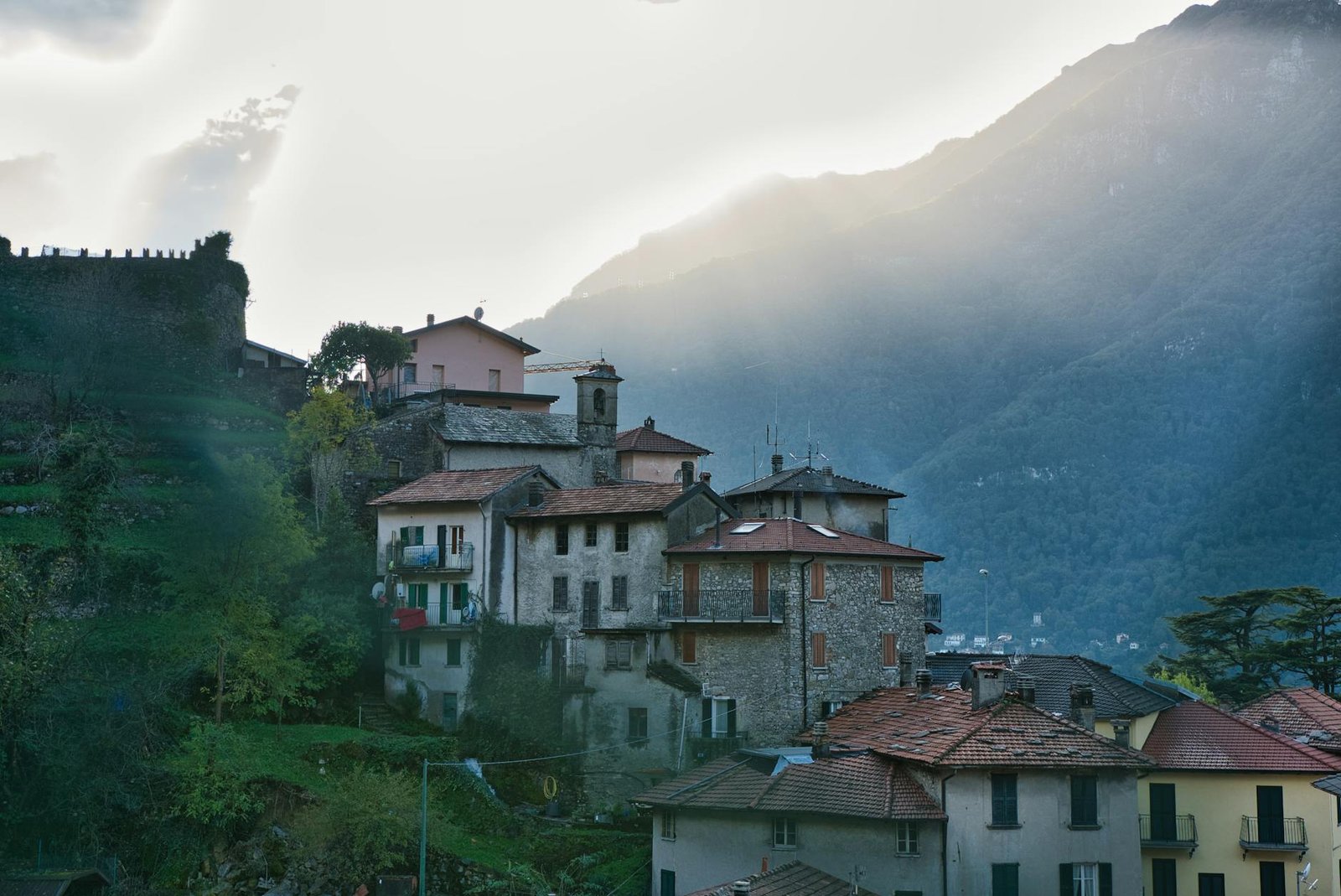 Picturesque view of a quaint village in Como, Italy, nestled against scenic mountains.