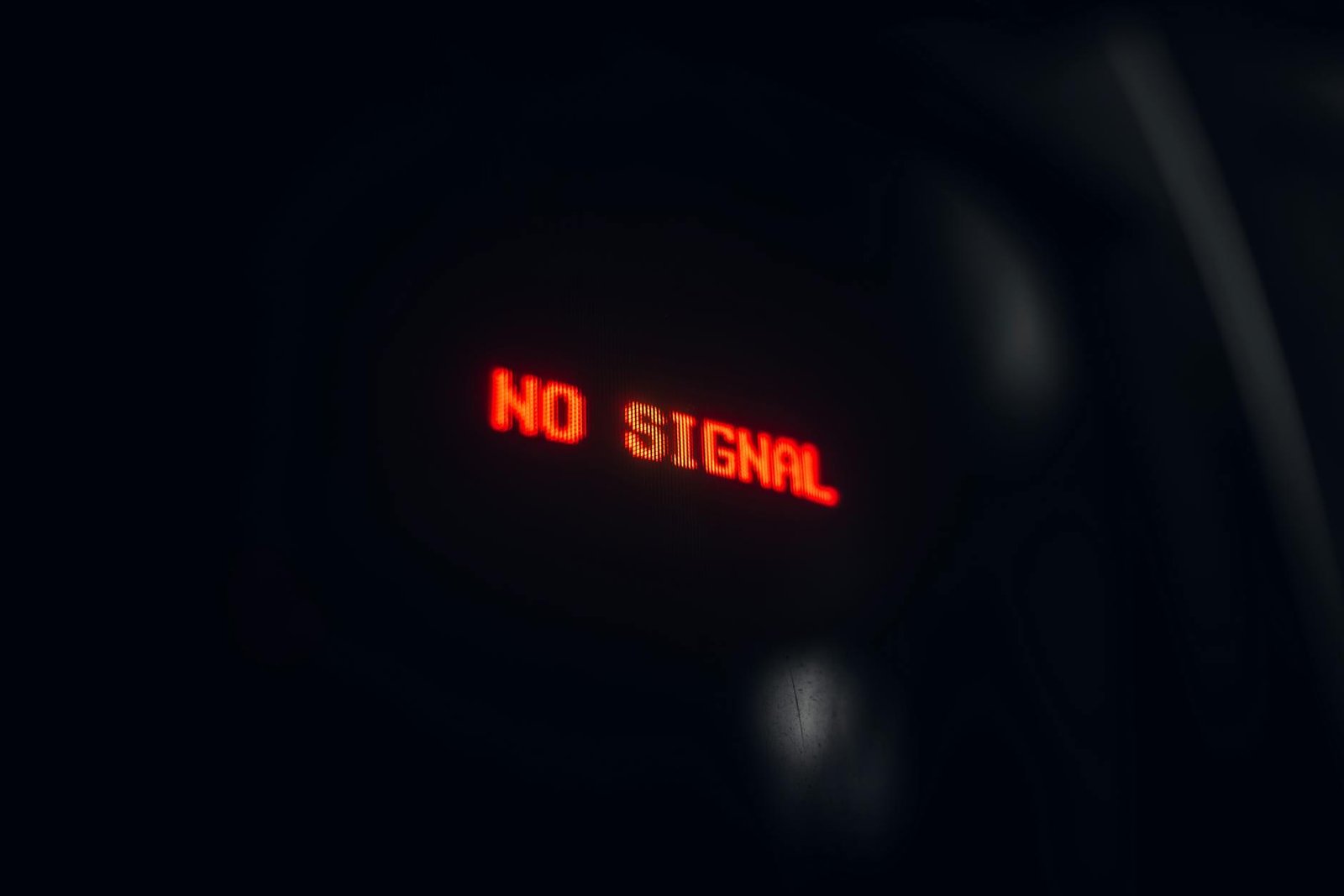 A red LED display indicating 'No Signal' in a dark setting, conveying a tech warning.
