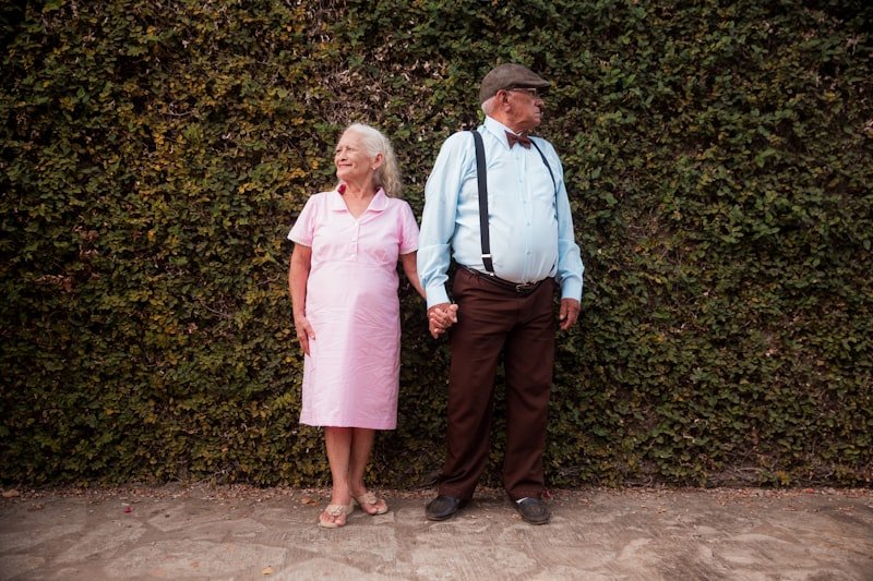 A man and a woman standing in front of a hedge