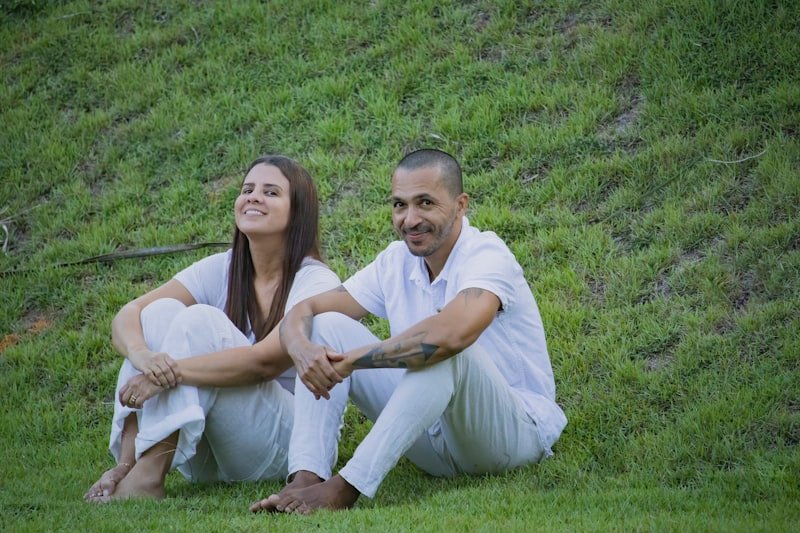 a man and woman sitting on grass