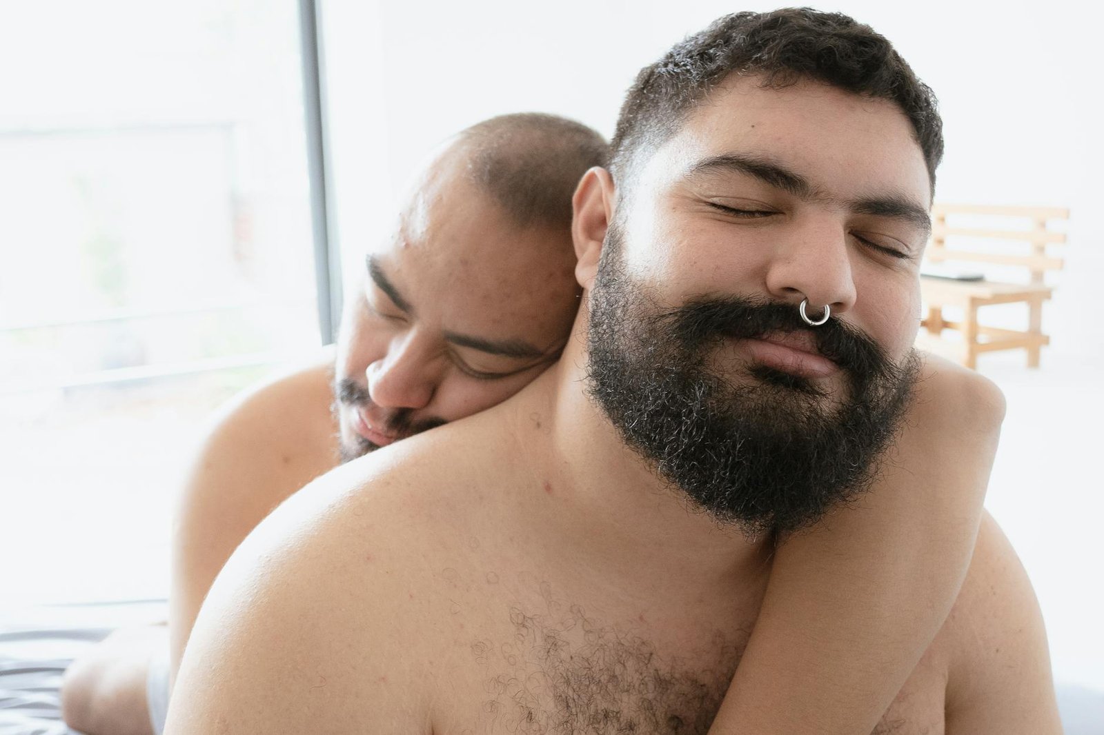 Close-up of a joyful couple embracing in a bright interior setting.