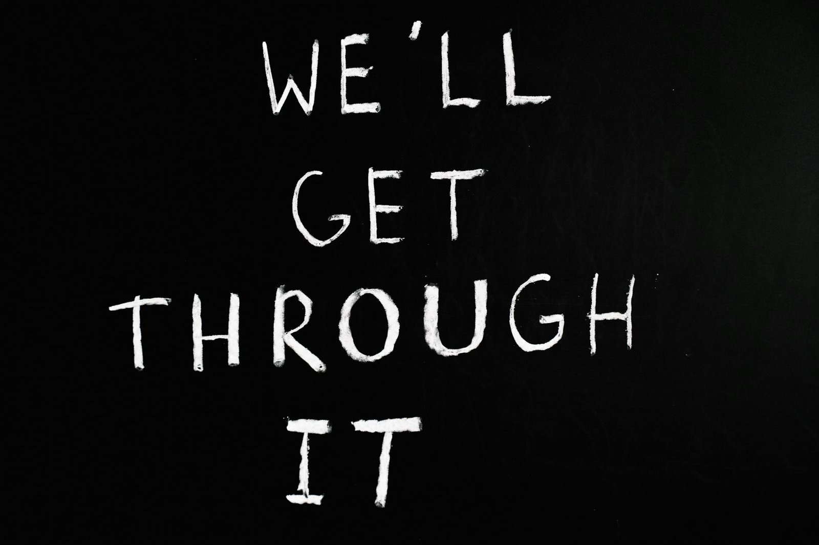 A motivational chalkboard message reading 'We'll get through it' on a black background.