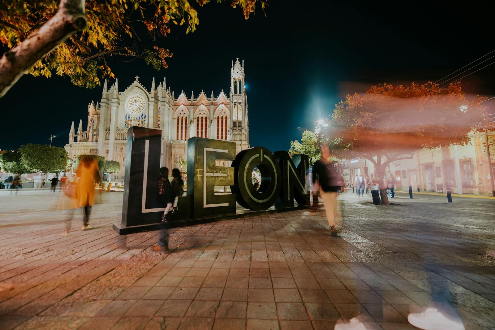 Vibrant night view of León's iconic cathedral with blurred motion of people, captured in México.