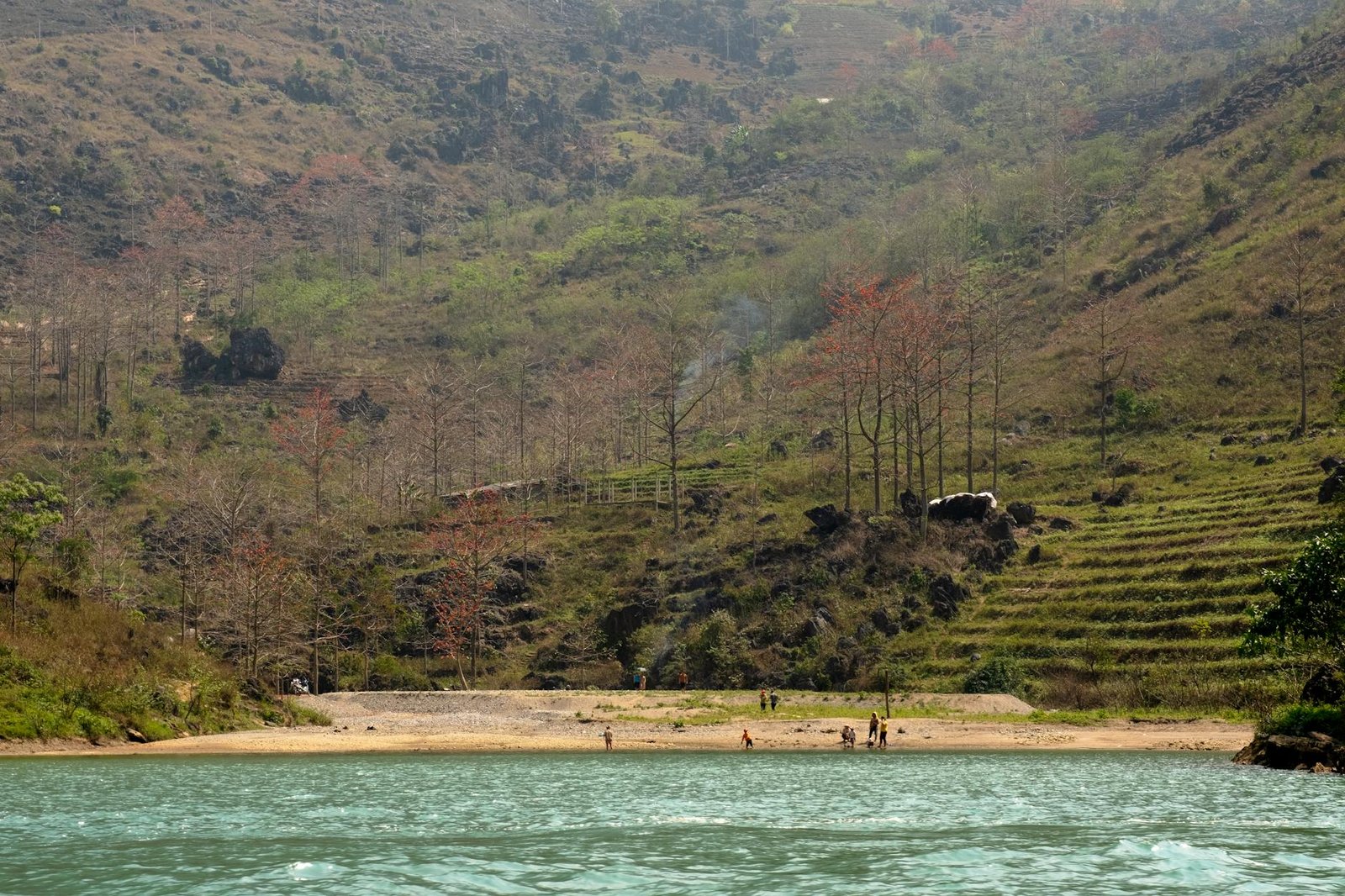 A picturesque riverside scene featuring tourists enjoying the serene landscape in Vietnam.