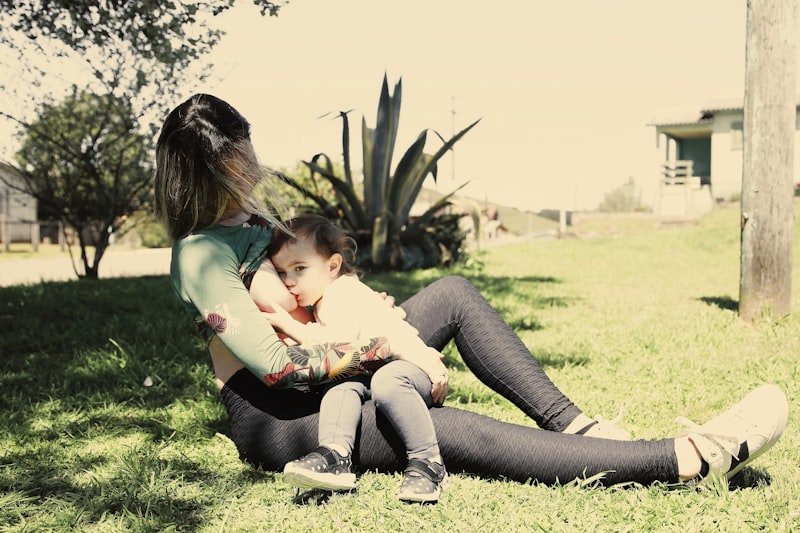 A woman sitting on the ground holding a baby