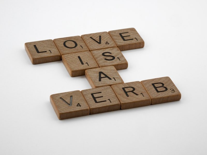 scrabble tiles spelling love is a verbb
